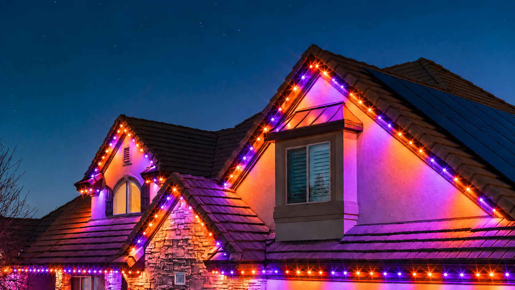 Trimlight permanent lights in orange and purple for Halloween, shown on an example home